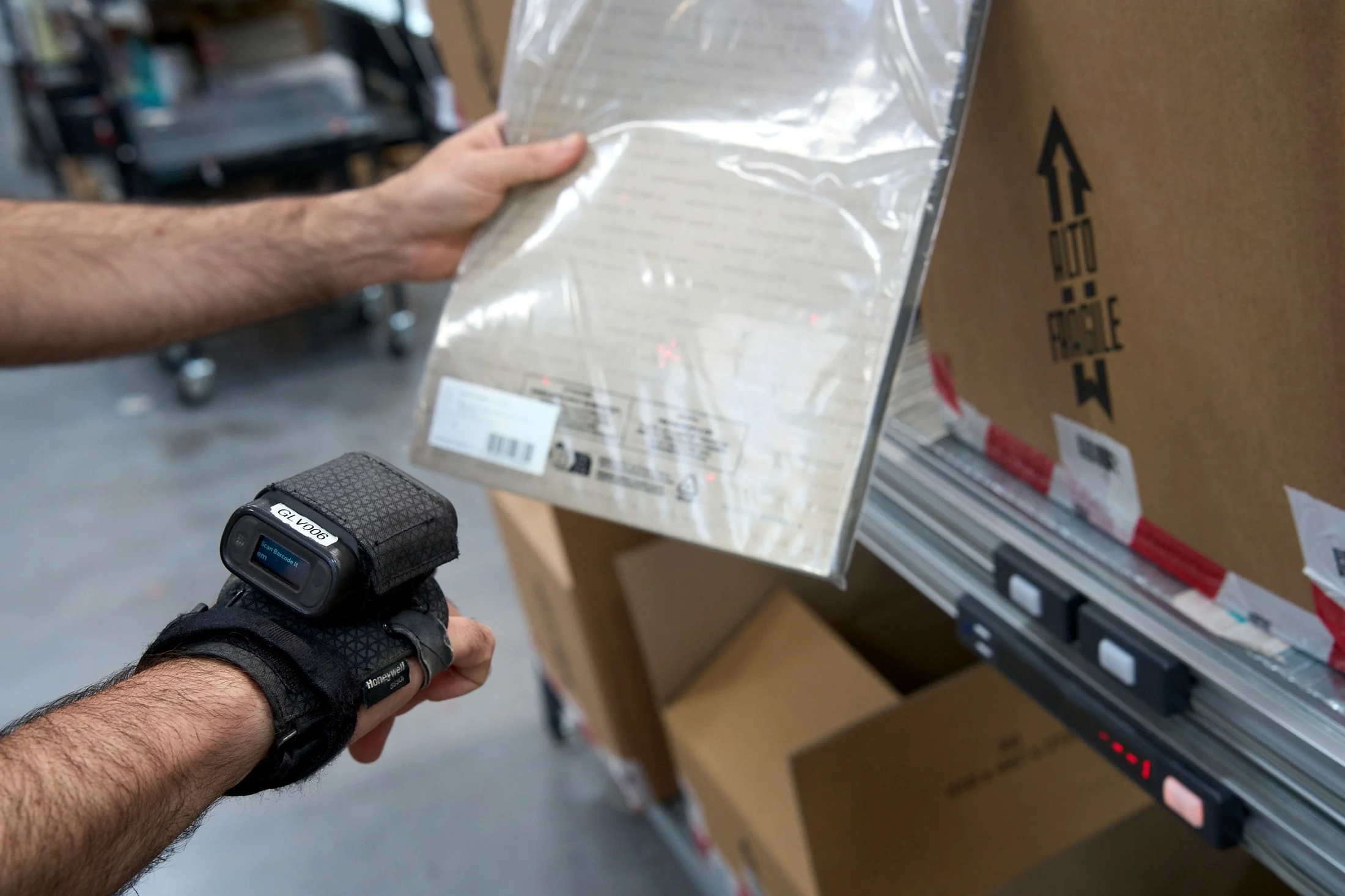 Operatore che scansiona un capo prima dell’imballo in una postazione di packing guidata dal WMS