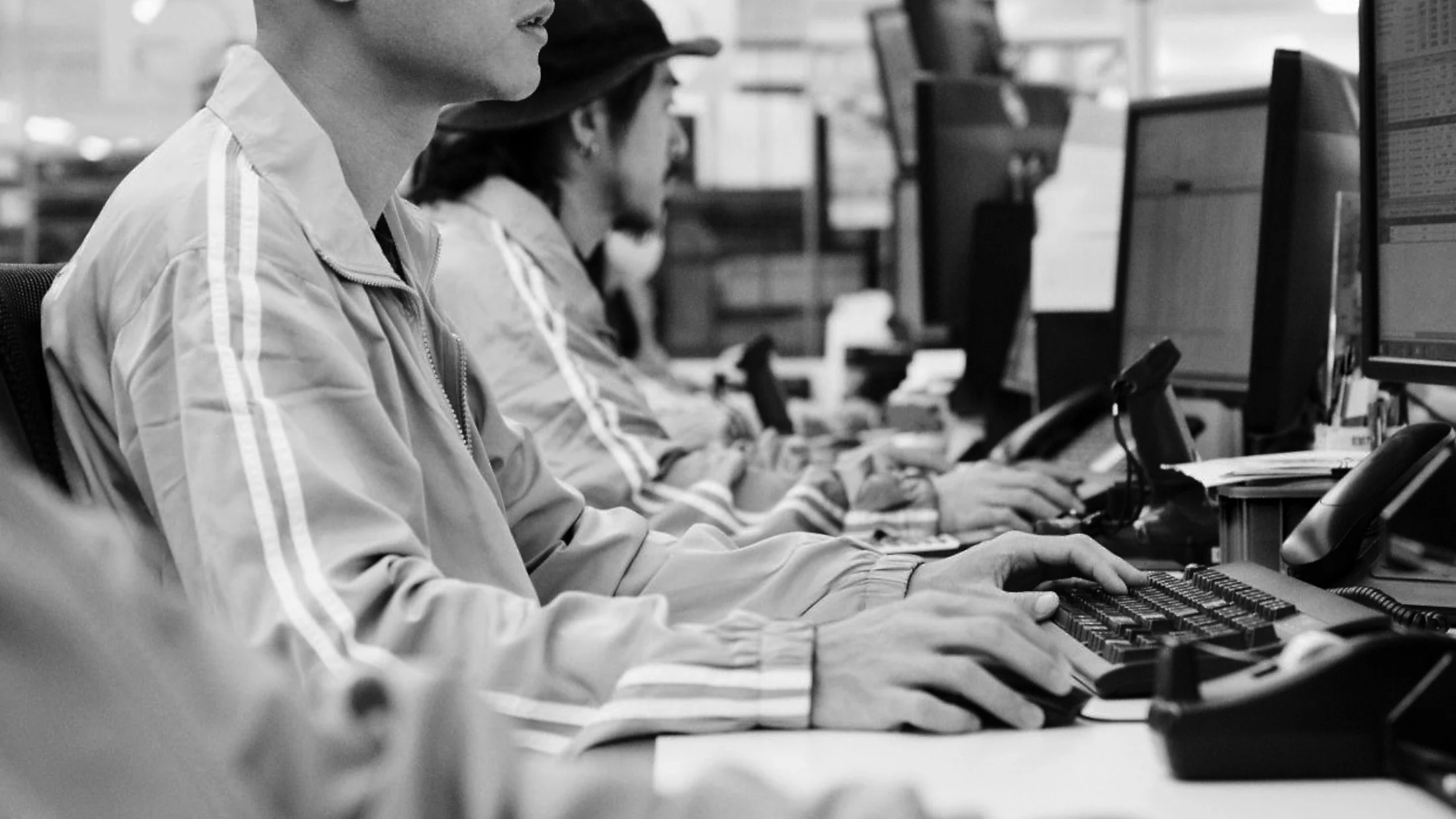Team in abbigliamento da lavoro grigio e bianco alle scrivanie in un ufficio open space