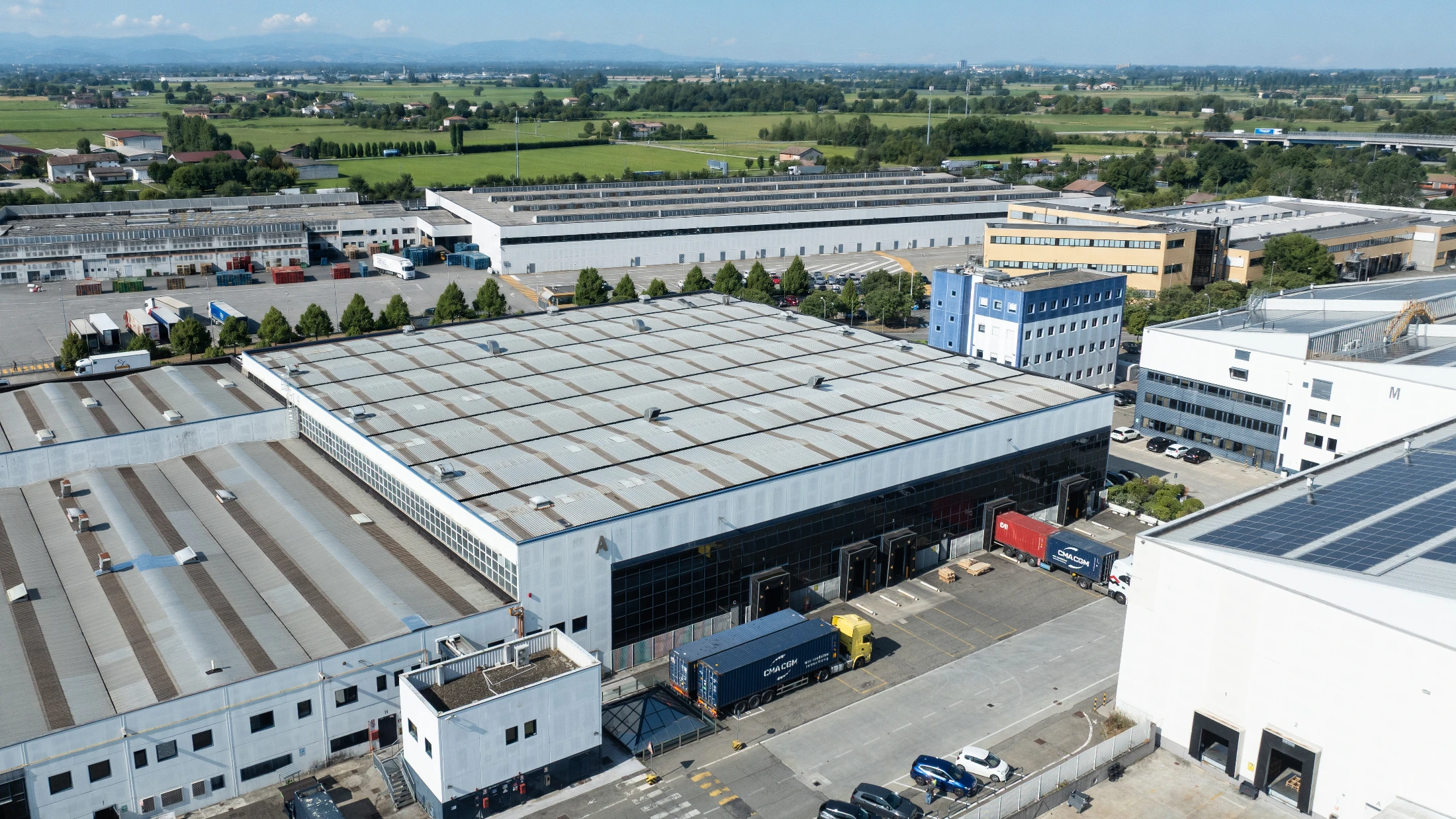Snatt Logistica Campegine warehouse compound with trucks docked for loading, fully automated logistics hub